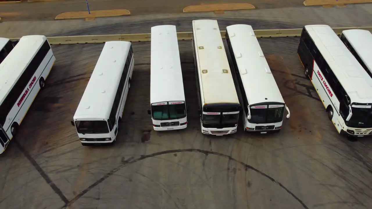 Aerial pan drone view white parked busses