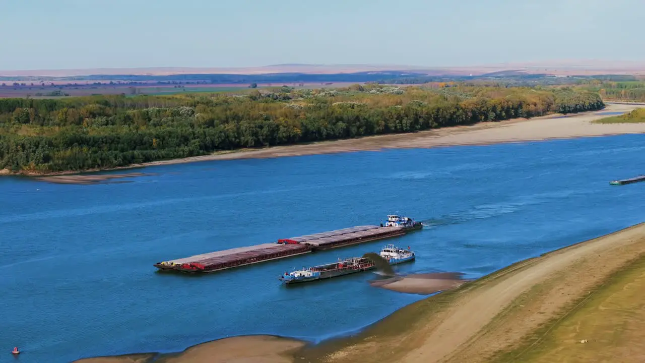 Aerial shot of a dredger unloading dredged sand on a big river other ships passing by sunny day