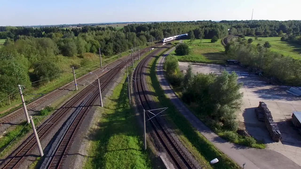 Aerial view of a high-speed train moving through the countryside on a sunny day