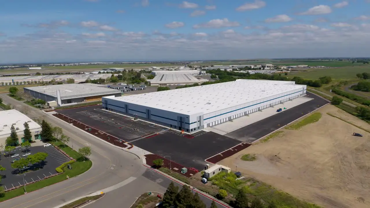 High orbiting drone shot of a new warehouse in an industrial area