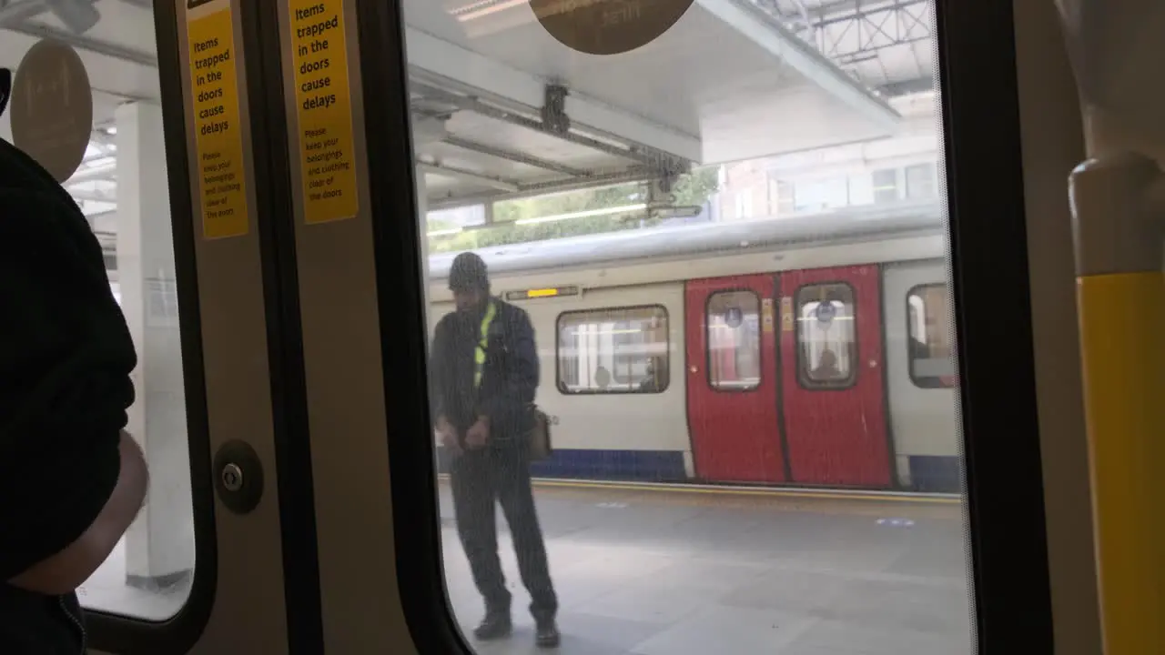 London District circle line underground train doors opening to Earls court station roundel