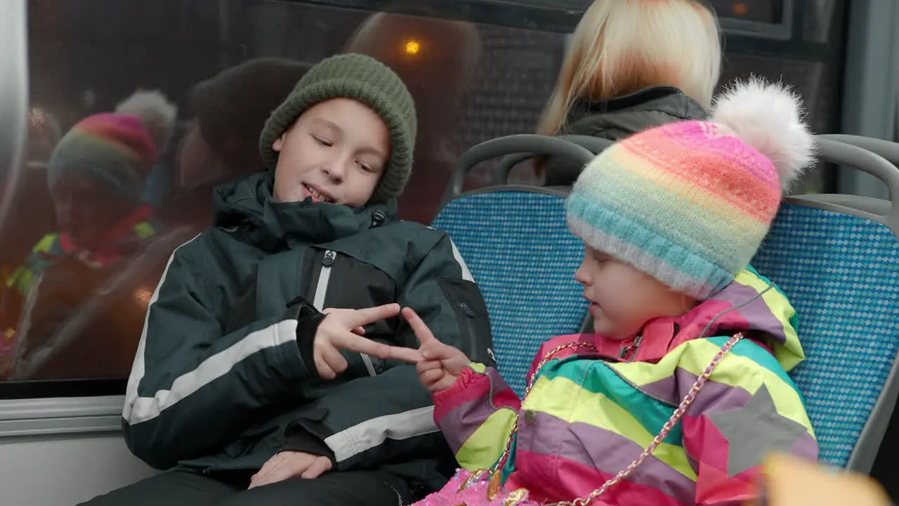 Sister with elder brother playing rock scissors paper in the bus