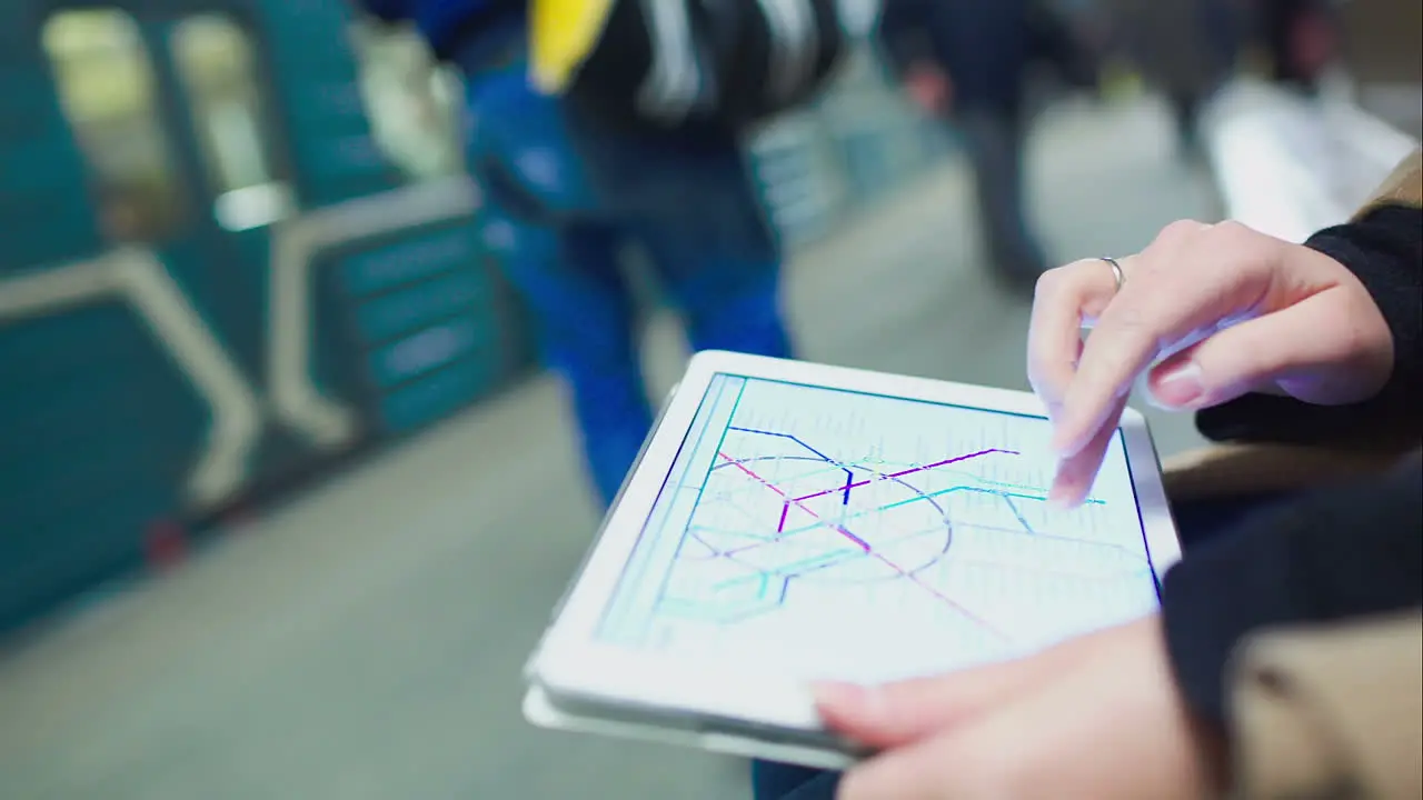 Woman searching station on underground map using touch pad