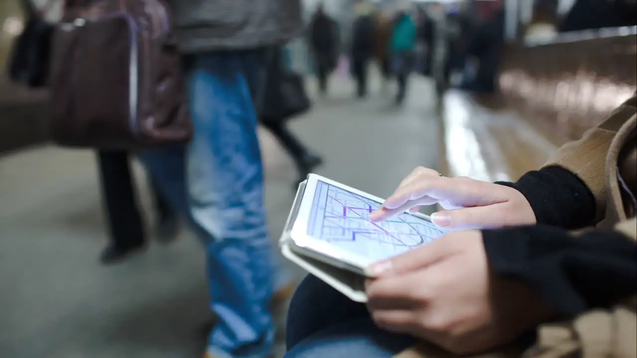 Woman in metro looking at undeground map on pad