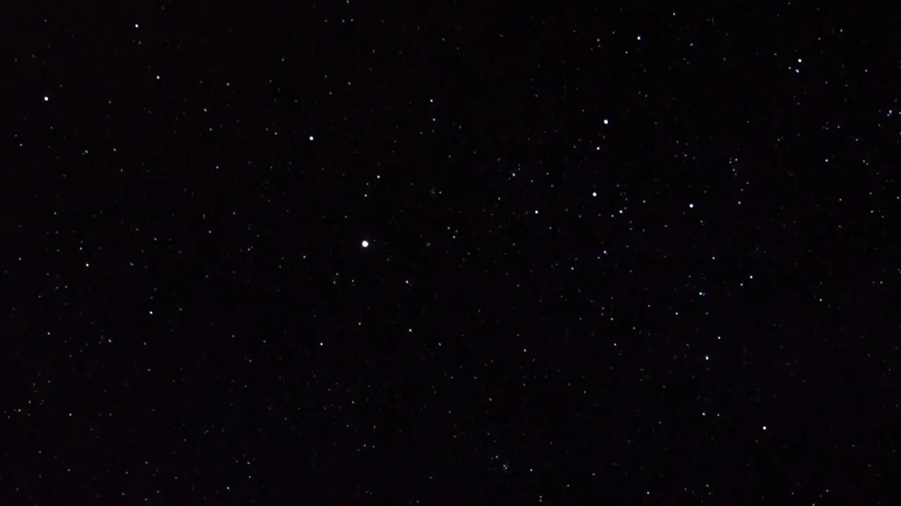 Panning shot across multiple shining bright stars on dark black sky