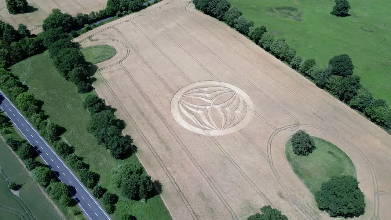 Aerial view descending across Warminster 2023 crop circle farmland alongside A36 highway