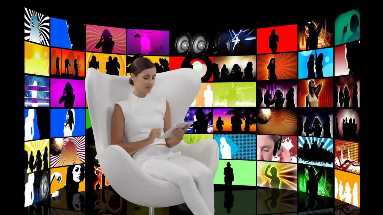 Woman sitting in a white chair and videos on screens