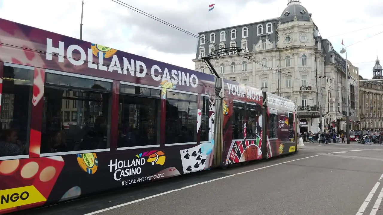 Tram on roadway in Amsterdam Netherlands Holland showing advertisements along the entire length of the vehicle and an efficient public transport system in the City