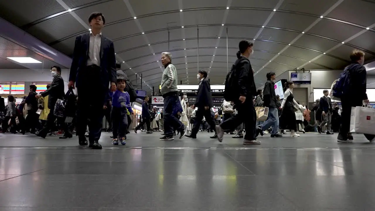 People walking in indoor train station towards their platform in Kyoto