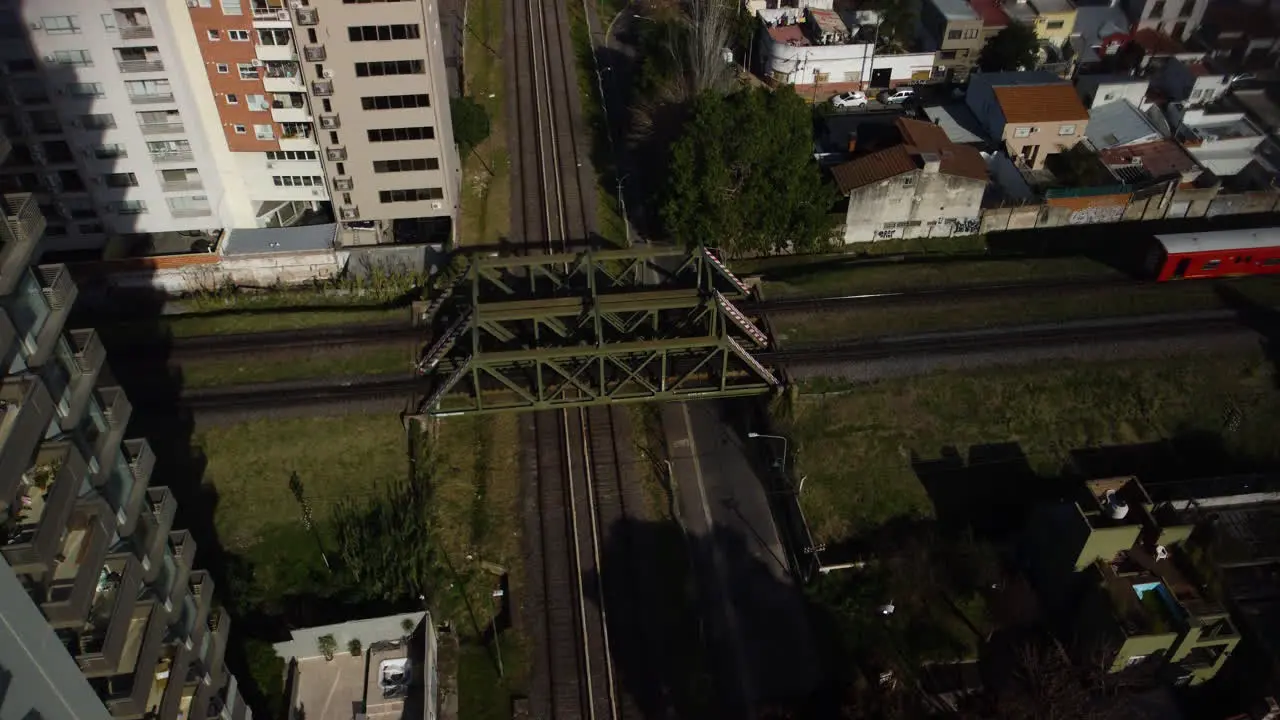 Red train rides on the railway bridge blue train rides on another railway road Buenos Aires summer traffic road crossing