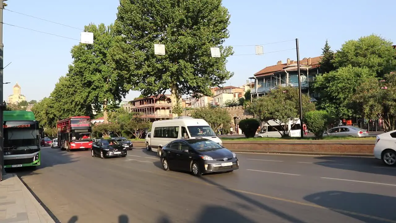 A Tbilisi City Tour Bus passing by a busy road