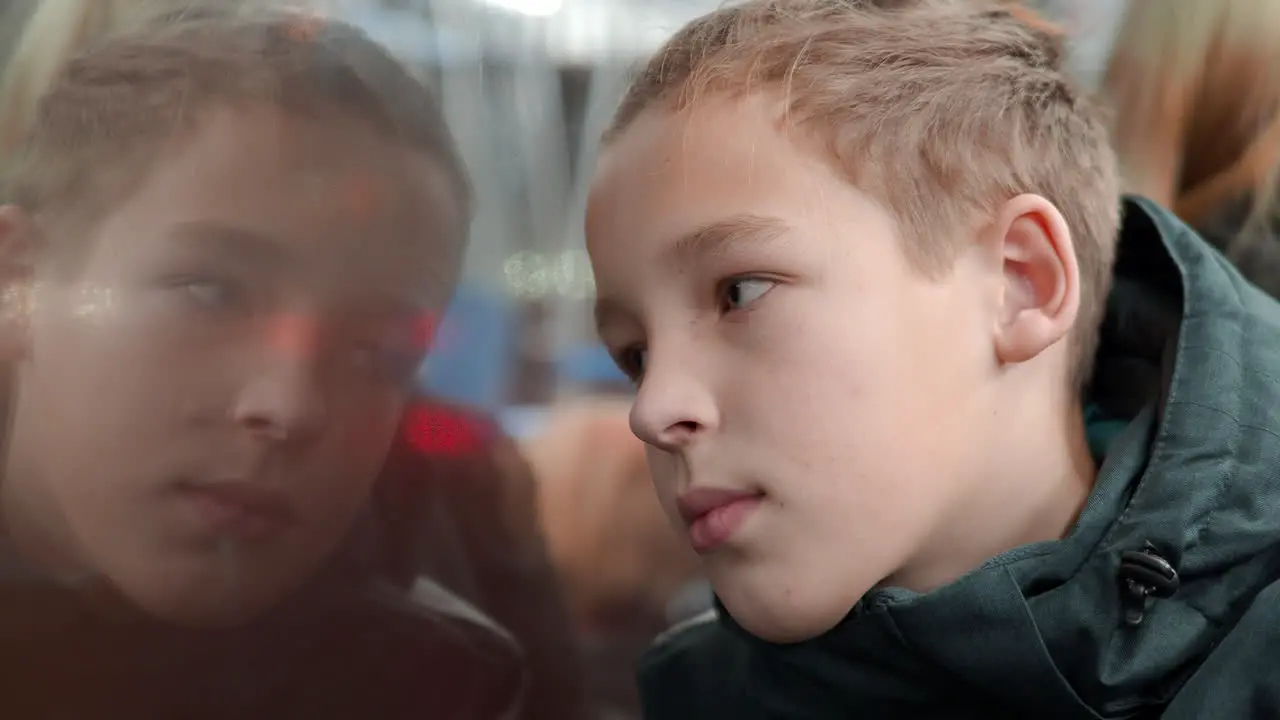 Boy looking at night city through the bus window