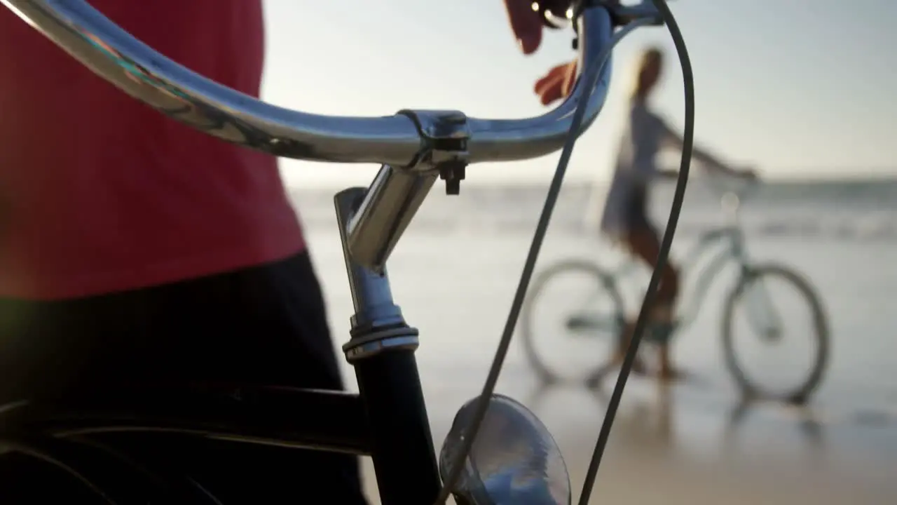 Man standing with his bicycle at beach