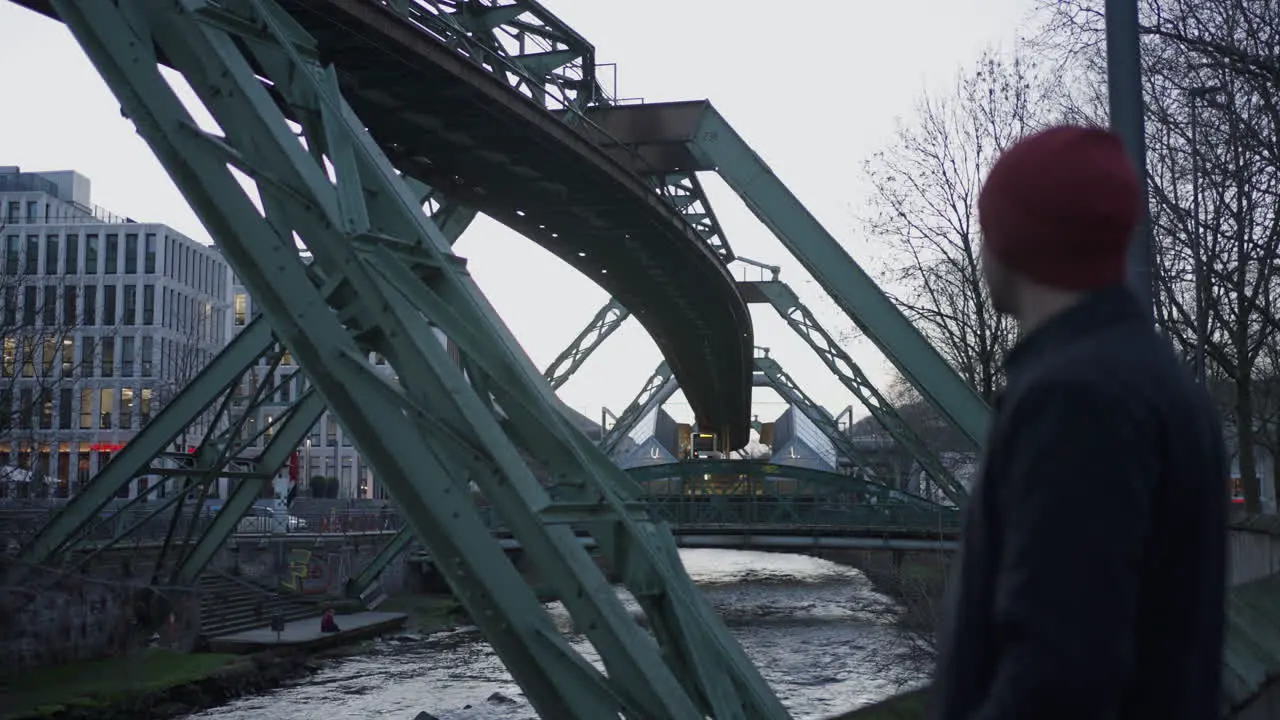 Young man admiring Wuppertal's suspended railway system in Germany