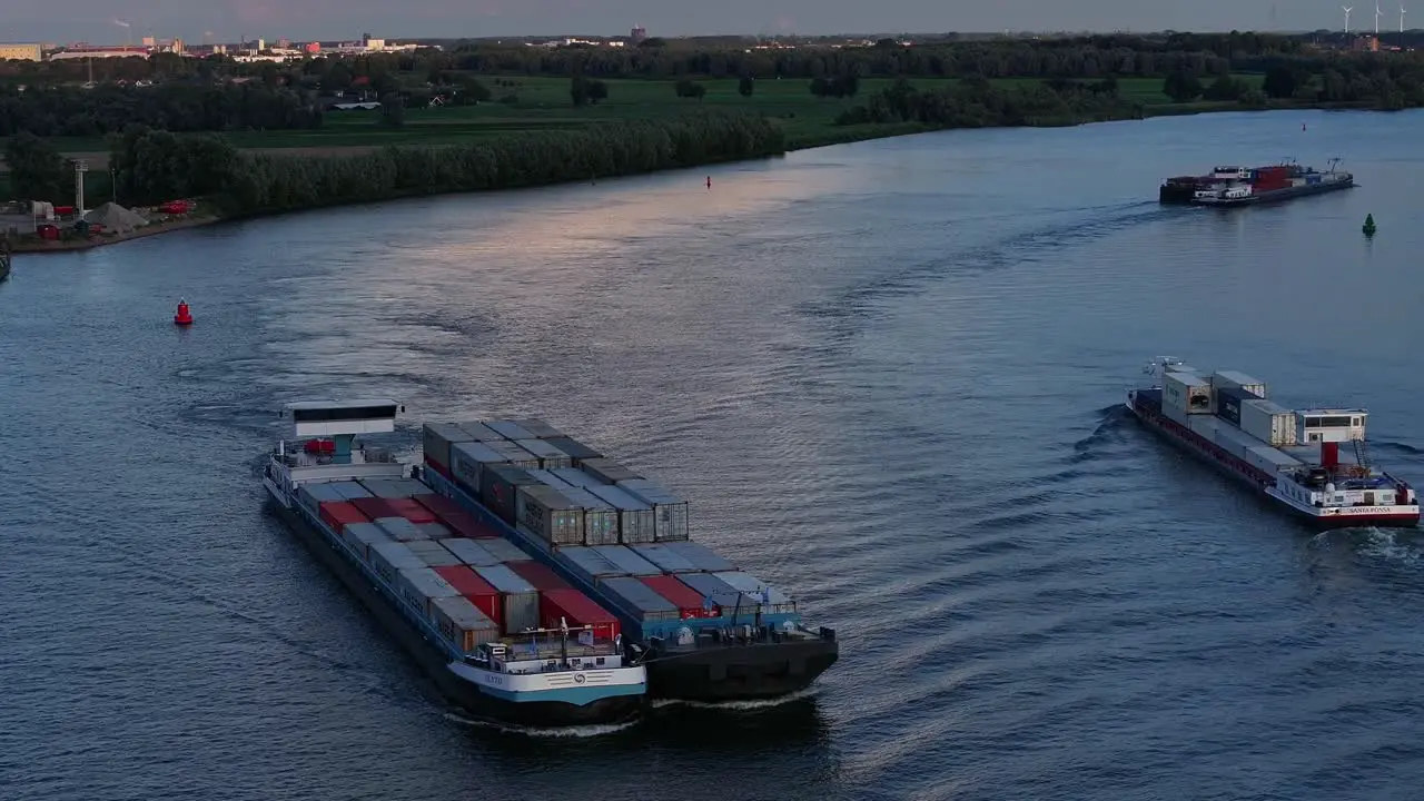 Combined shipping container ships sailing on Dutch rivers passing another ship