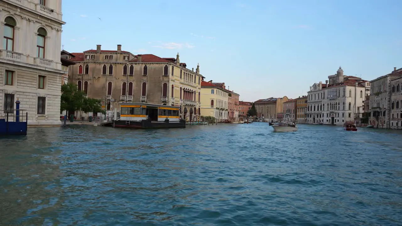 Traghetto navigating Venetian canal with motorboats and gondolas heading to dock