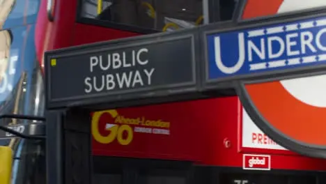 London Bus Passing London Underground Sign