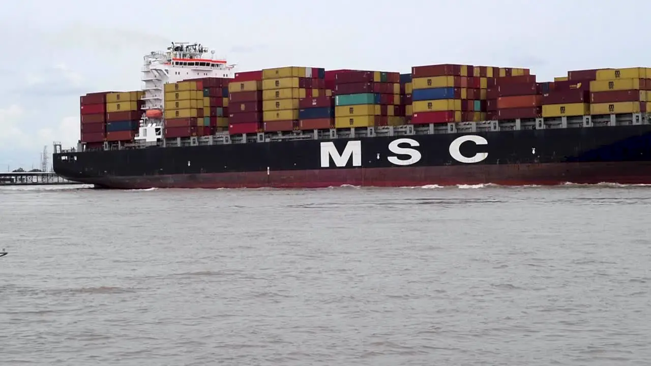 Fully loaded cargo ship moves down the Mississippi River past the port of New Orleans