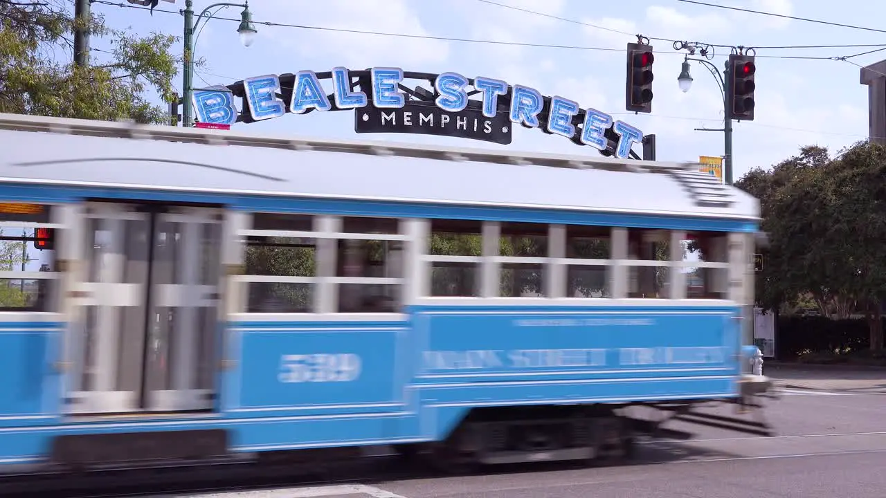 Memphis trolley car on a busy street outside Beale Street entertainment district arch