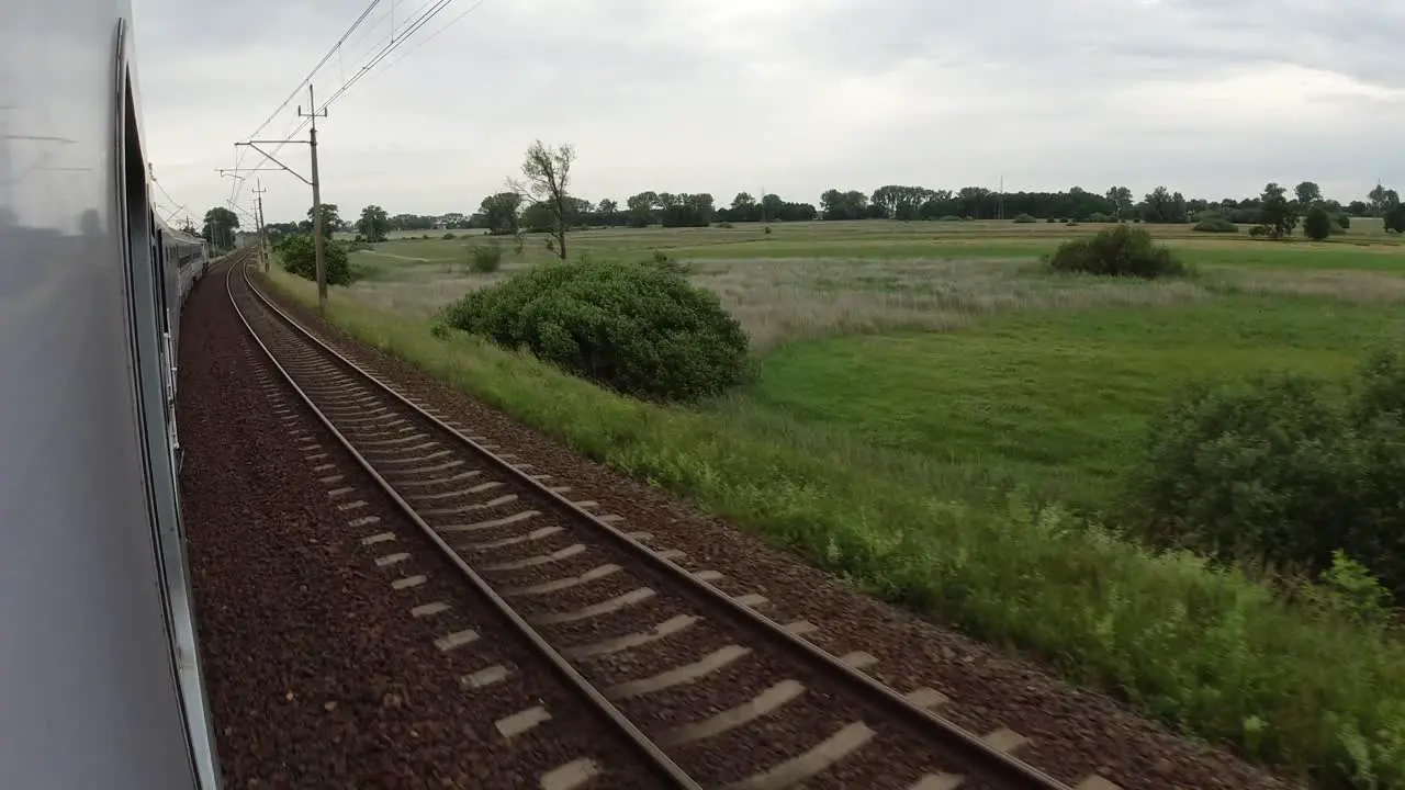 A view of the train tracks and the fields from a fast moving train