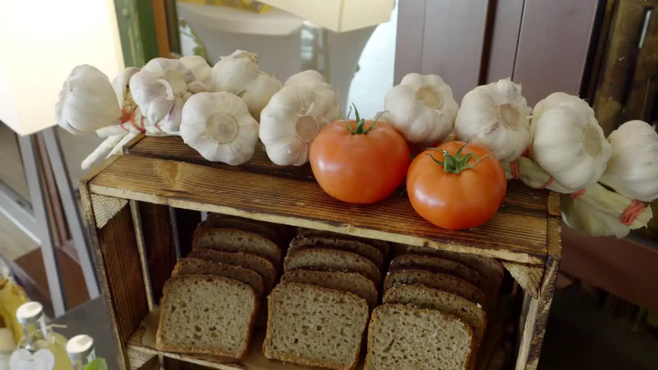 Rural table made from a wooden crate on which there are tomatoes garlic and bread