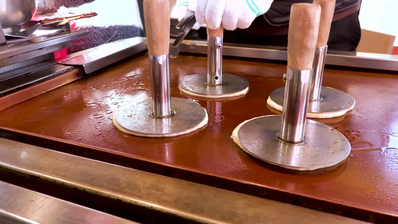 Korean street food vendor prepares Hottdeok  a Korean style pancake