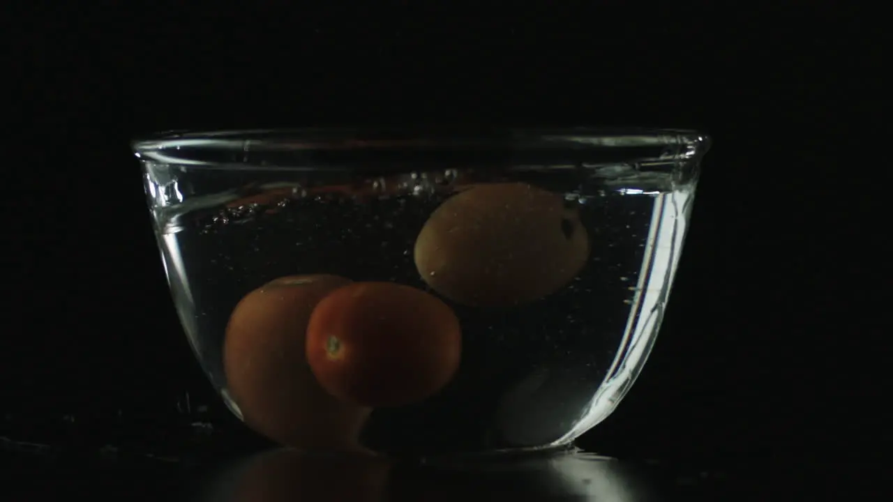 Slow-mo of Tomatoes Dropping in Bowl of Water