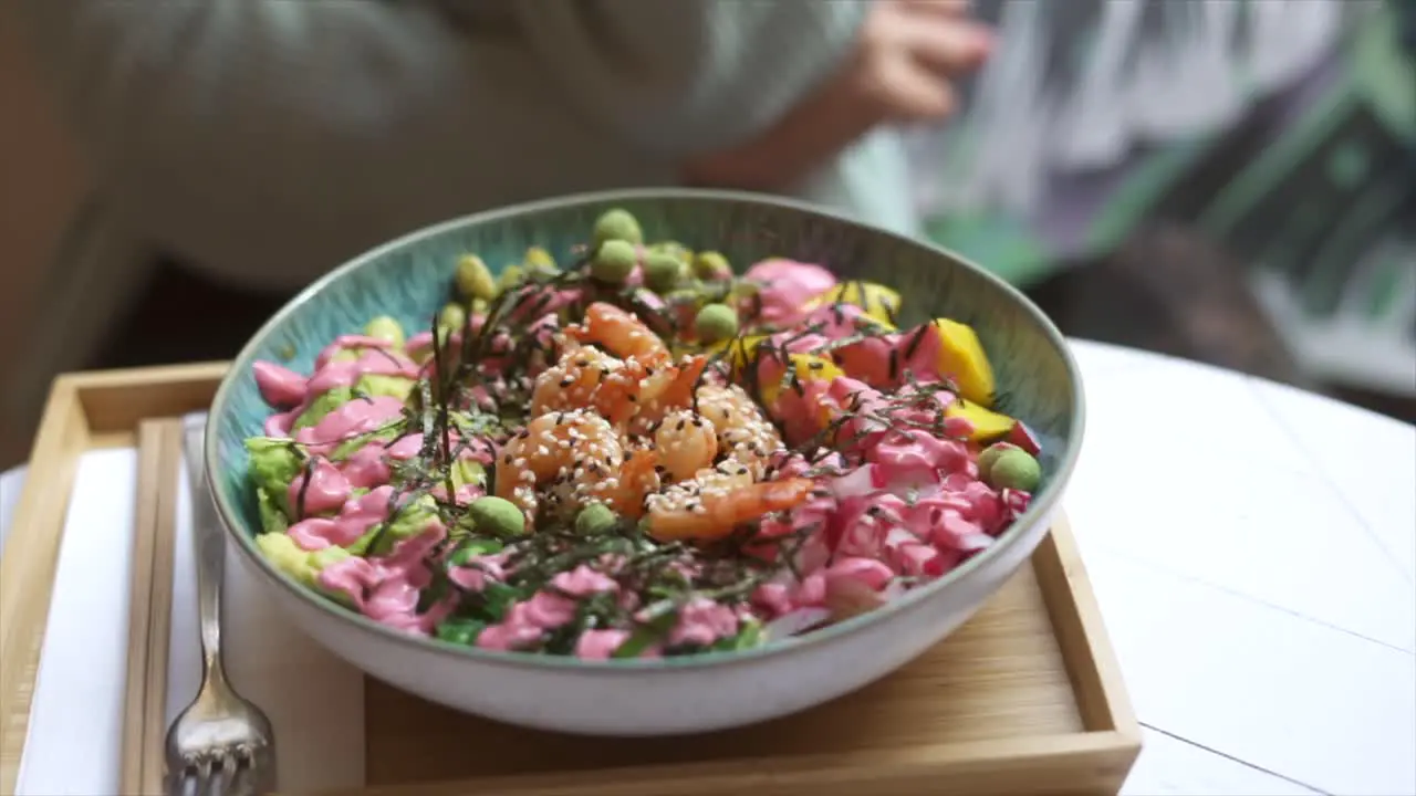 Panning close up of delicious poke bowl in restaurant