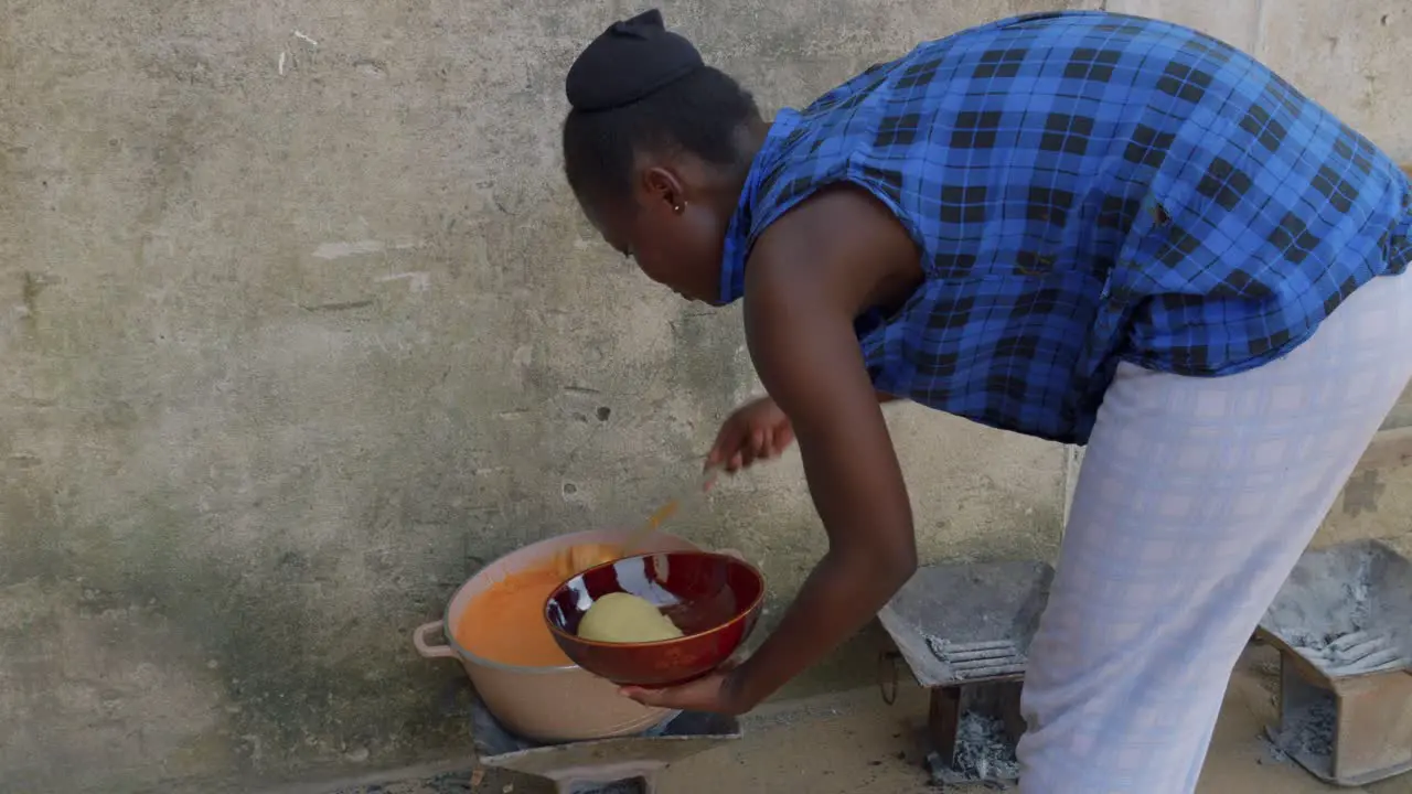 Fufu traditional west africa ghana food preparation on the street of rural remote village black female woman cocking food