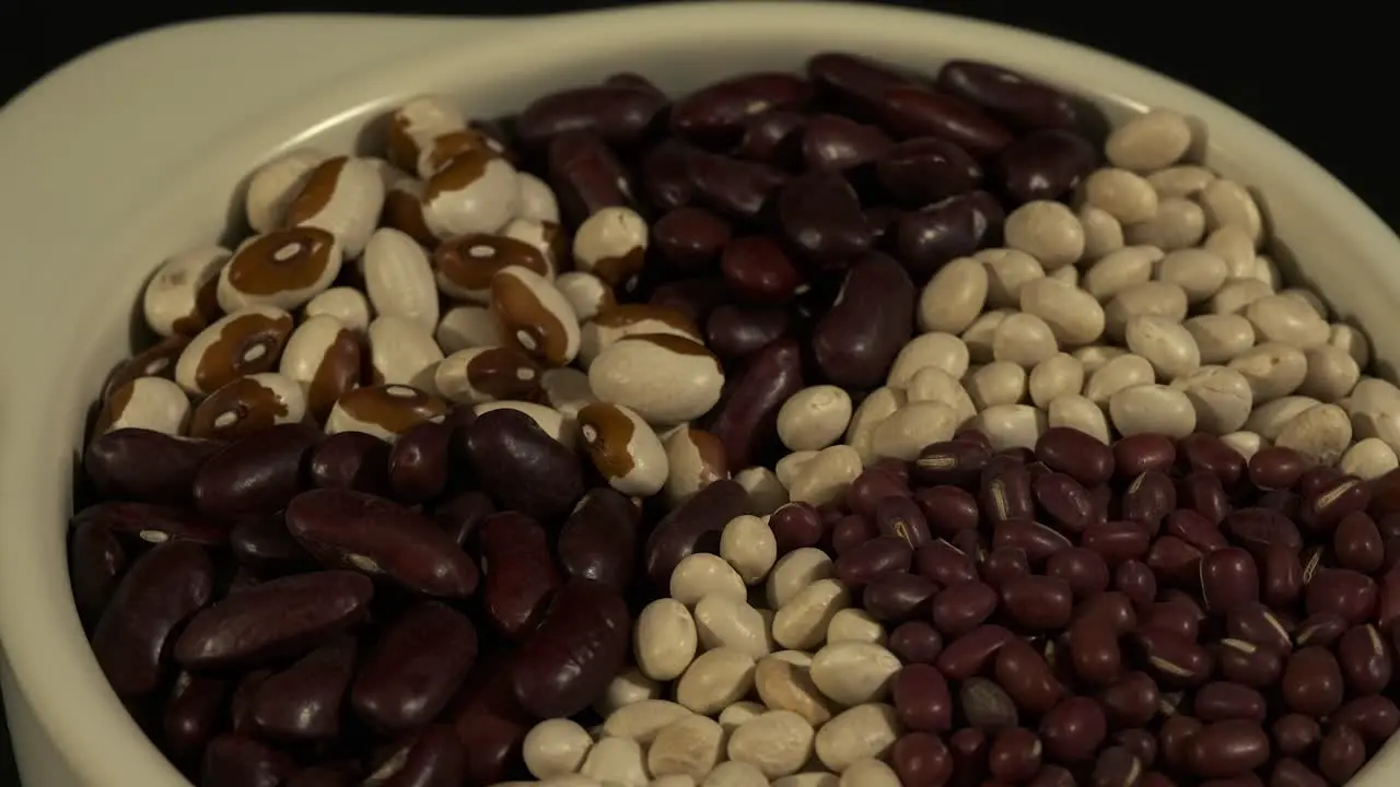 Spoke pattern dried beans in white bowl rotate in full frame close up