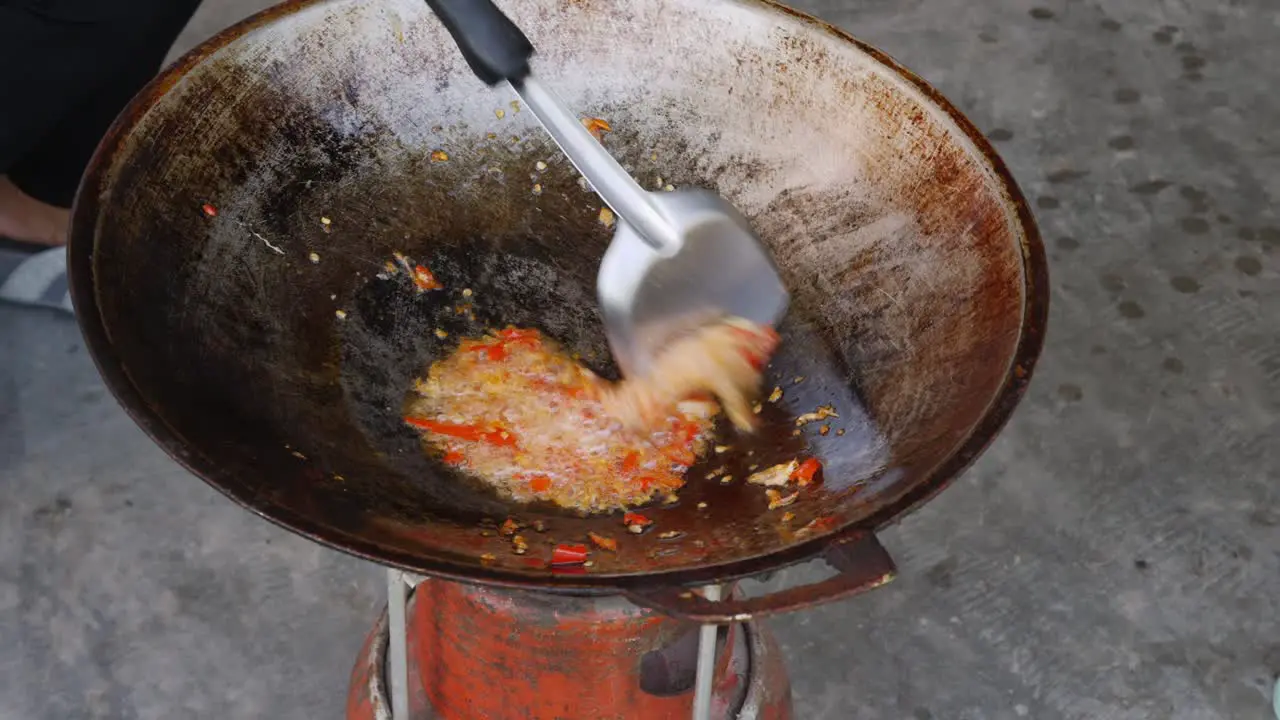 Preparing food sauteing ingredient been stir in rustic wok Street food