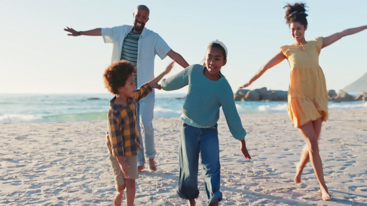 Running airplane and happy family at the beach