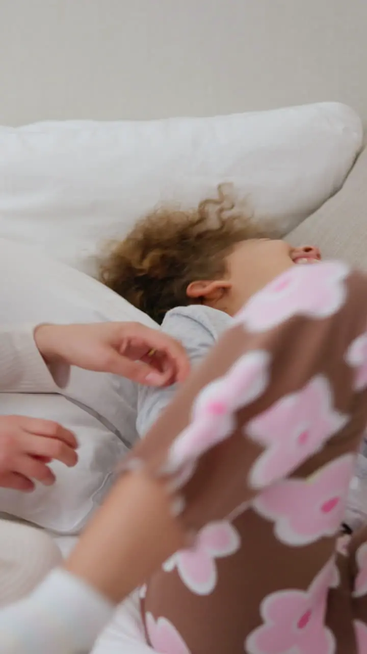 Happy family laughing and tickling child on bed