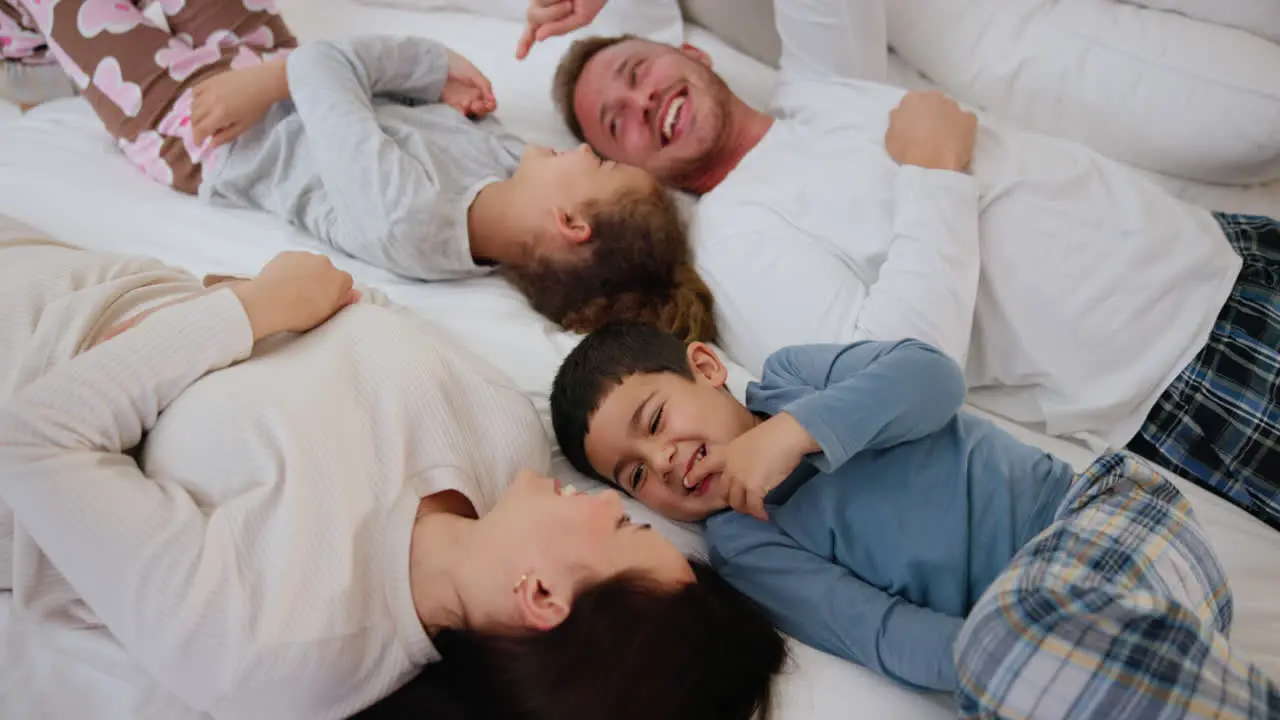 Top view tickle and happy family in a bed