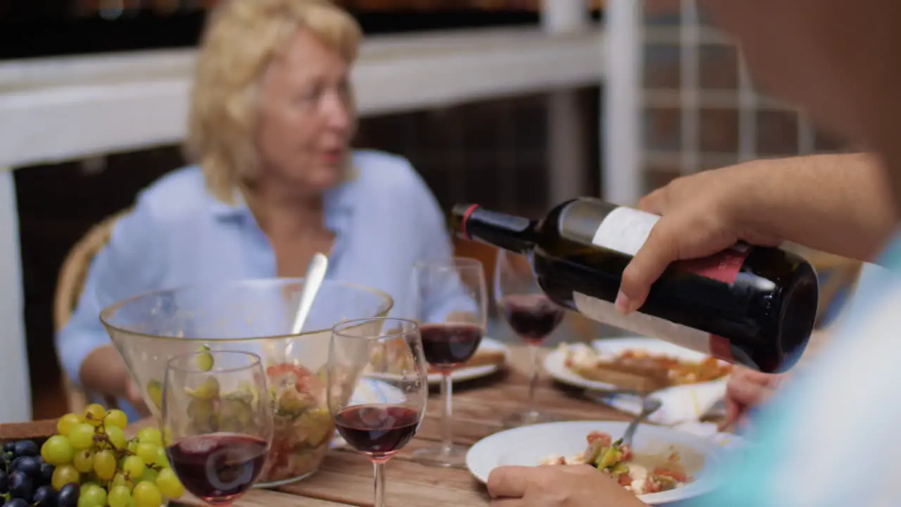 Man pouring red wine during the dinner