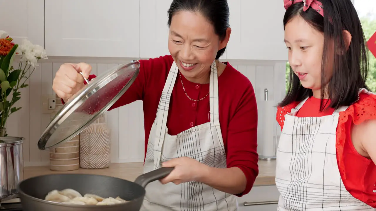 Asian family mom and kid cooking dumplings in pan