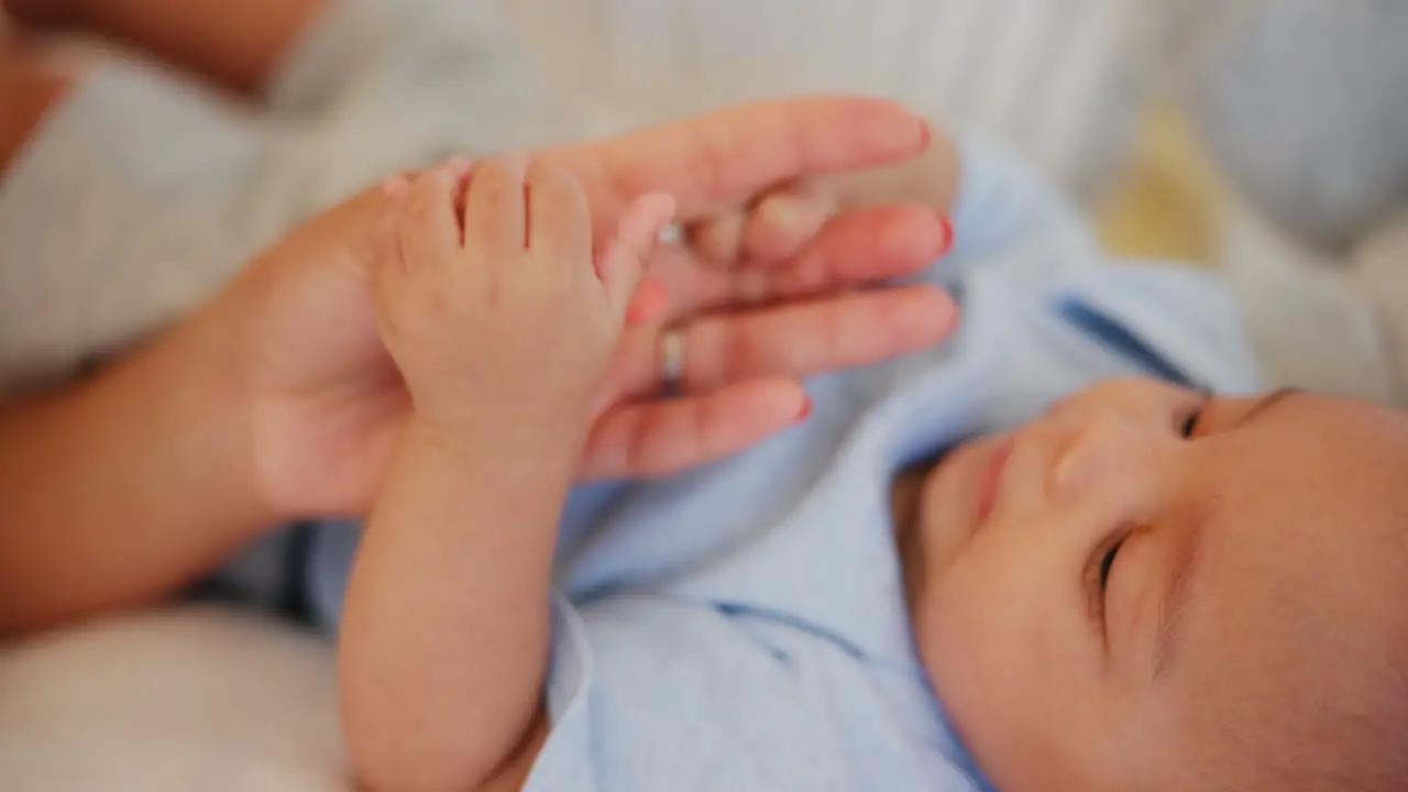 Mother holding hands and baby for playing