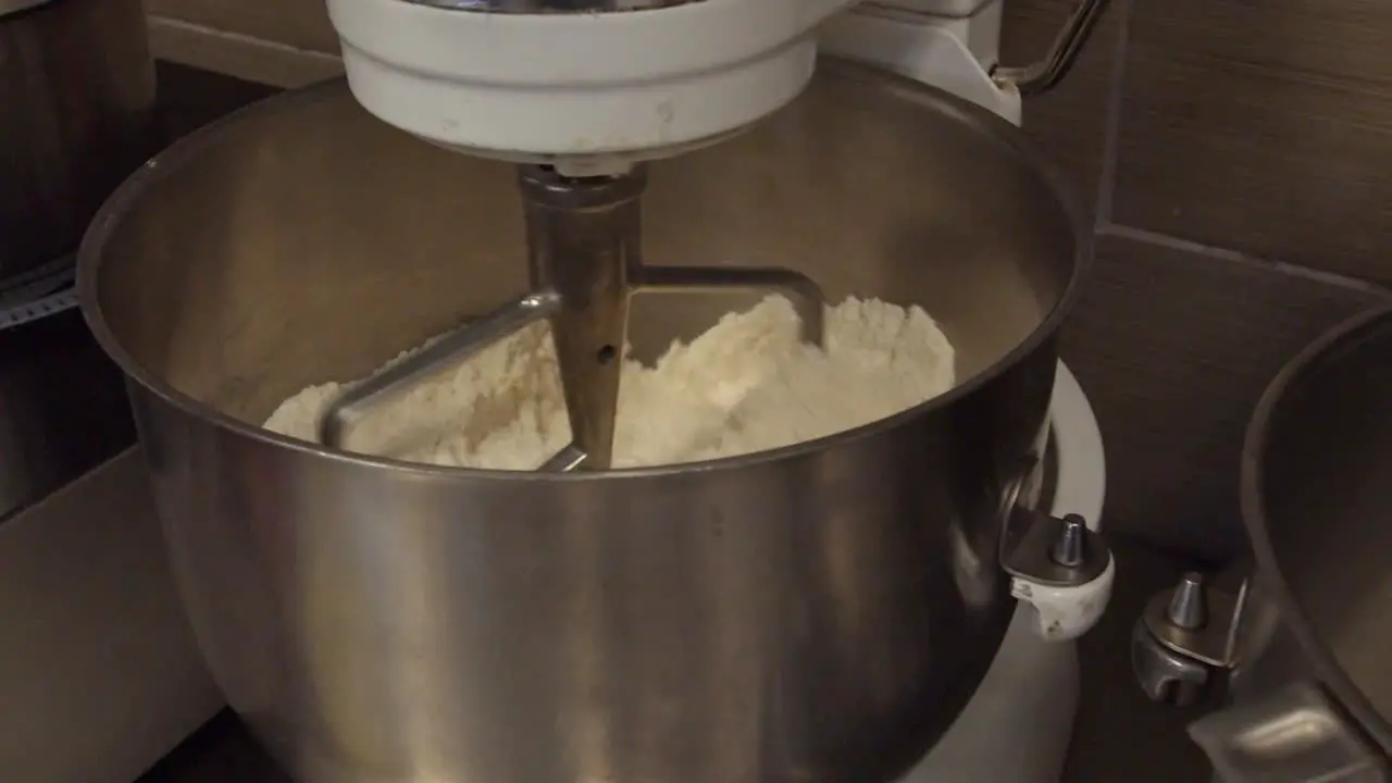 Mixing Flour in an industrial mixer during the day time in a bakery