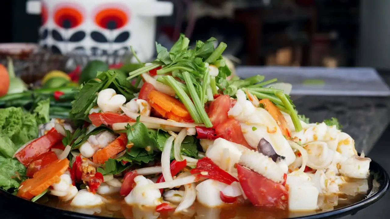 Close of delicious Thai squid and vegetable dish being garnished