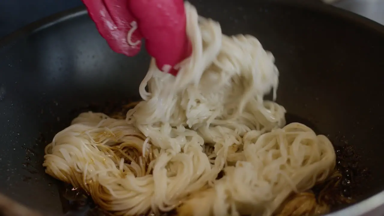 close up of cocking chinese noodle in a pan asiatic traditional food