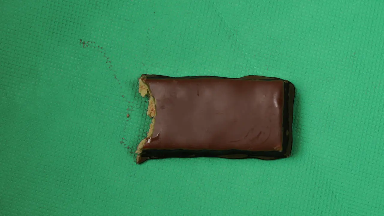 Stop motion of eating chocolate bar bite by bite green background