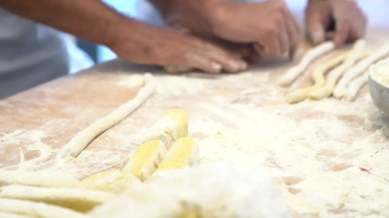 human hands make and modelling piece of pasta on a table made