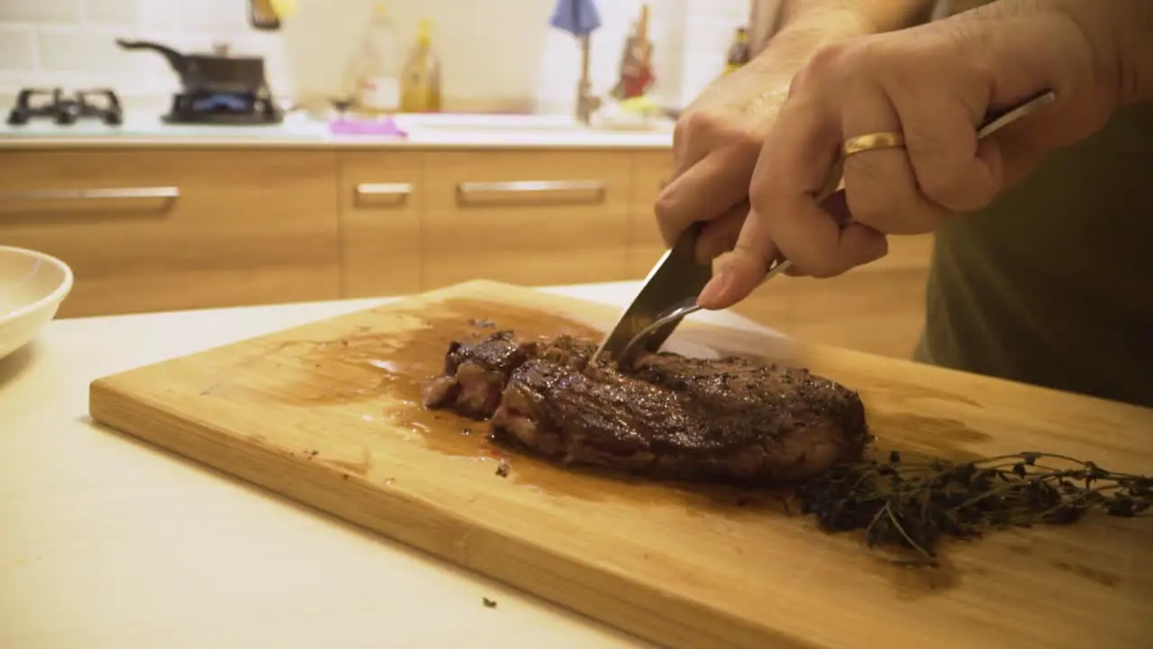 Person Cutting Medium Done A4 Wagyu Steak On A Wooden Board At The Kitchen