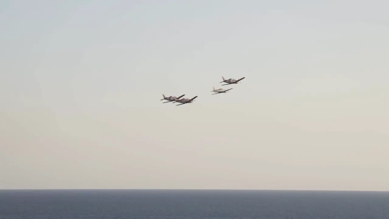 wide shot from far away of airplanes in air show with sea bottom