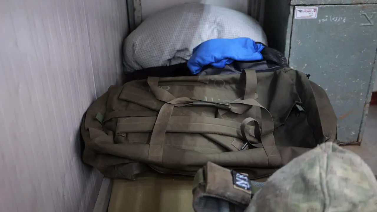 Soldier putting his personal effects on a bed army backpack and uniform