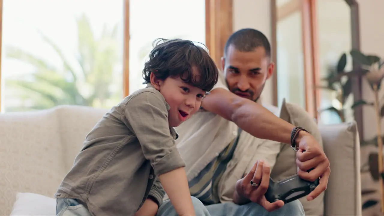 Father son and video game controller on sofa