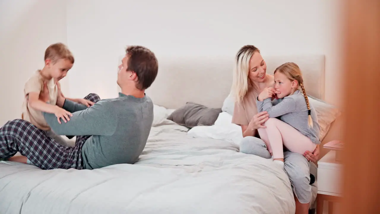 Happy family playing and airplane game on bed