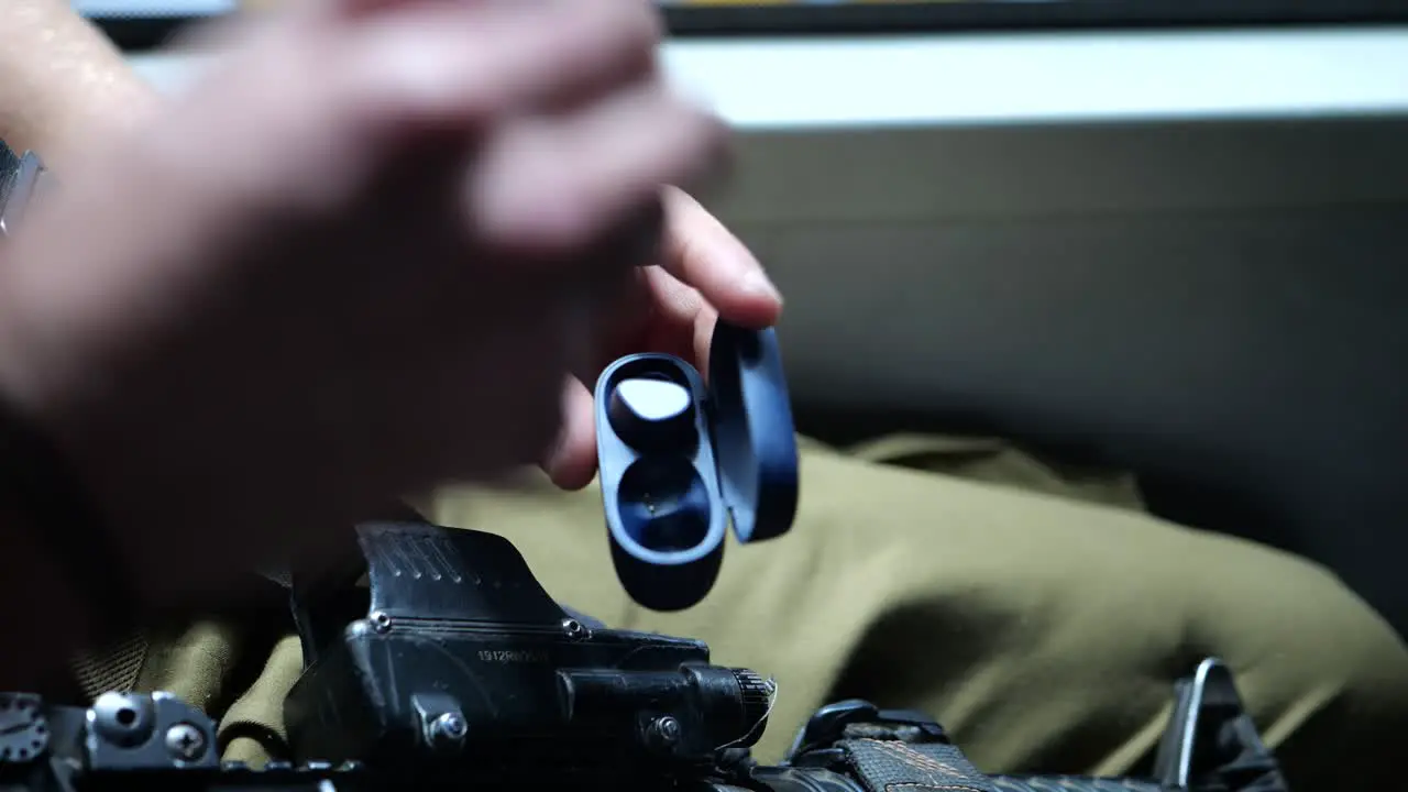 Soldier taking earphones out of the box close up