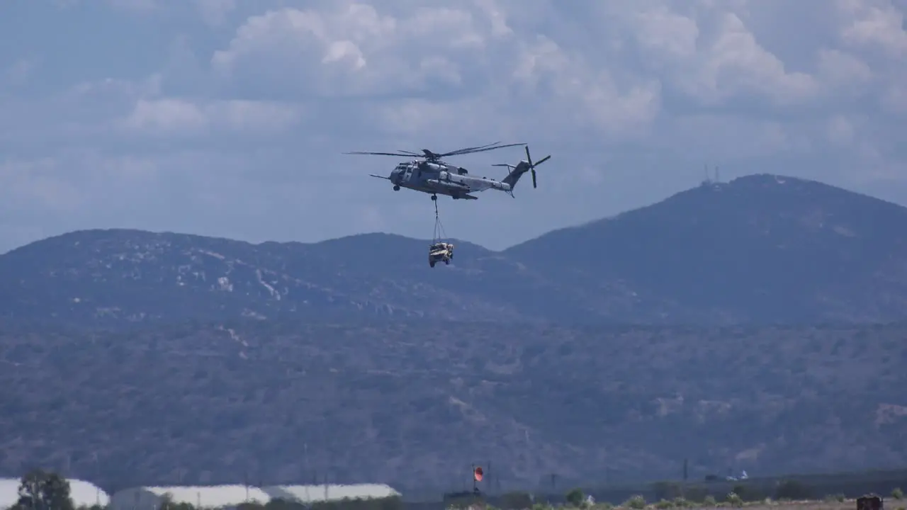 Military Helicopter carrying payload over mountain