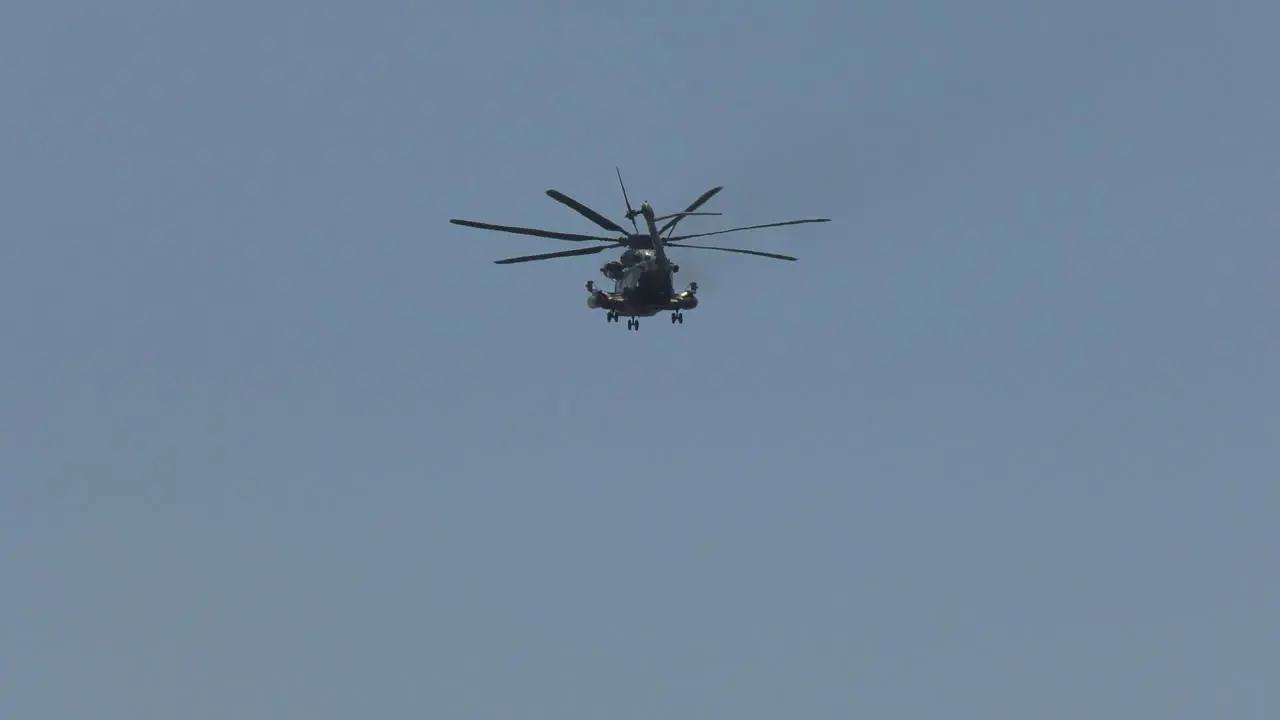 Military Cargo helicopter flies through blue skies